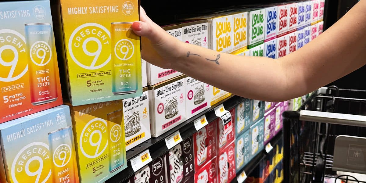 A hand reaches for THC seltzer on a convenience store shelf in Louisiana.